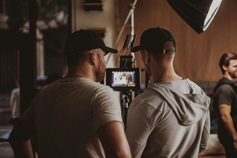 Two crew members reviewing a shot on a small on-set monitor